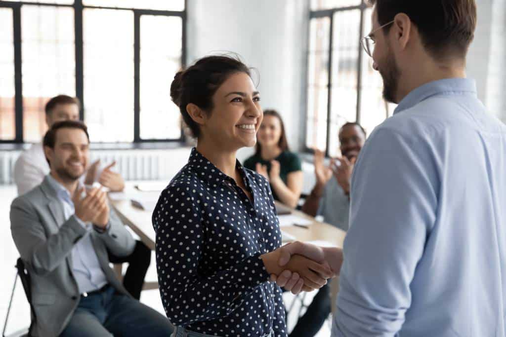 Male employee shaking hands with female employee